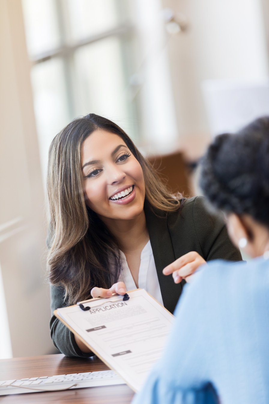 Hispanic bank officer shows loan application to client